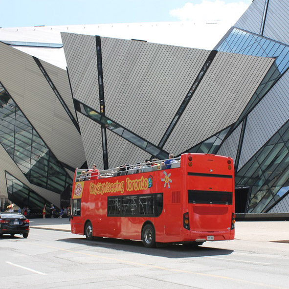 Double-decker bus passing by the Royal Ontario Museum.