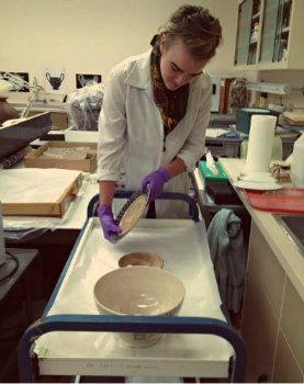 Emily Ricketts. Holding a Portneuf Spongeware plate in Conservation Lab. Photo by Jaime Clifton-Ross